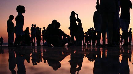Un grupo de personas en la playa a contraluz